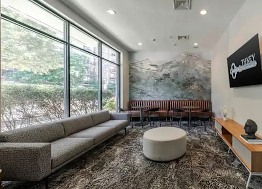A room with a large window and a mountain mural on the wall.