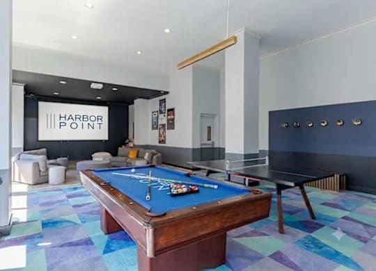 A pool table in a room with a sign that says Harbor Point.