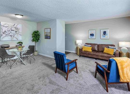 A living room with a grey carpet and furniture.