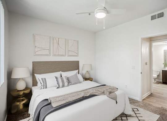 a bedroom with a large bed and a ceiling fan