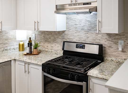 A modern kitchen with a black stove top oven.