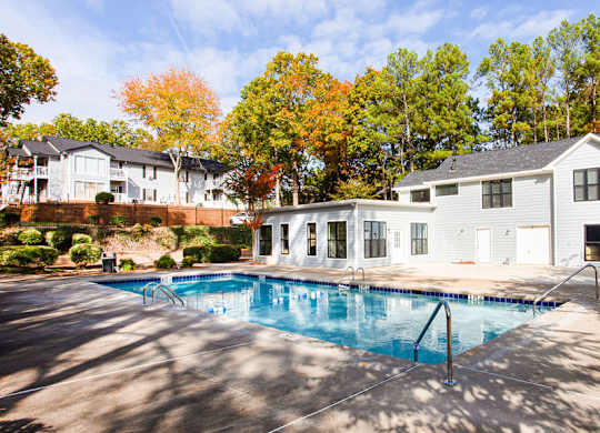 A swimming pool in front of a house.