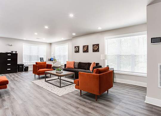 A living room with a grey floor and white walls.