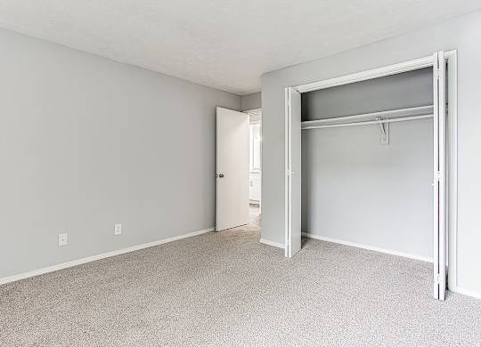 A white room with a closet and a door.