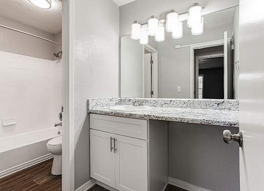 A bathroom with a marble countertop and a white toilet.