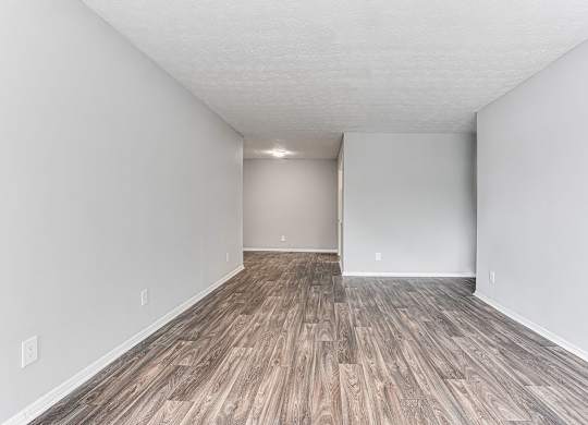 A room with wooden flooring and white walls.