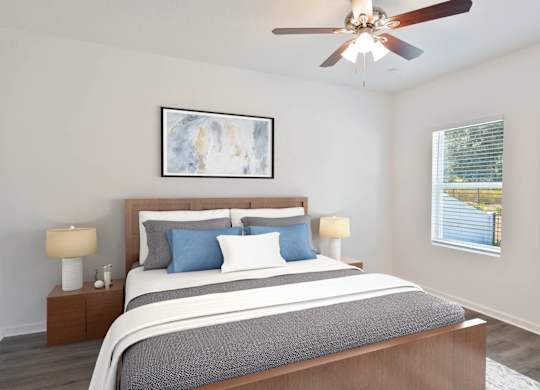 A bedroom with a large bed and a ceiling fan.