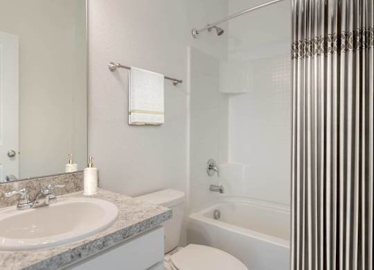 A white toilet sits next to a sink in a bathroom.