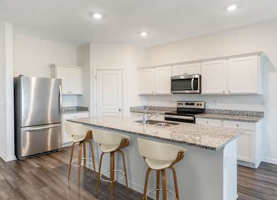 A kitchen with a granite countertop and white cabinets.