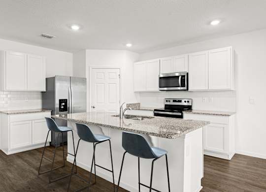 A kitchen with white cabinets and a granite countertop.