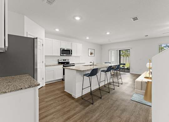 A modern kitchen with white cabinets and a central island.