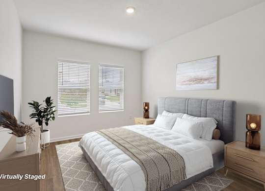 A bedroom with a large bed, a nightstand, and a TV mounted on the wall.