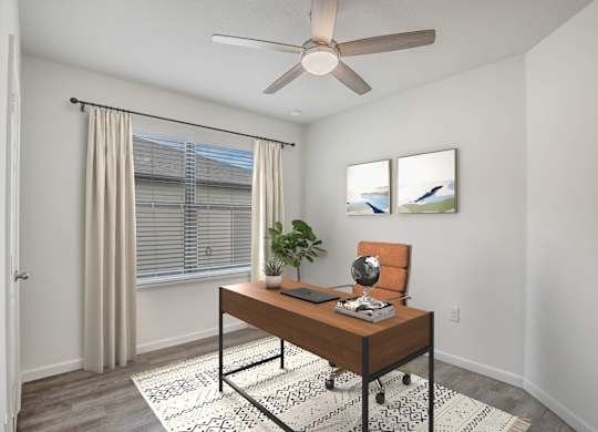 A room with a brown desk and a ceiling fan.
