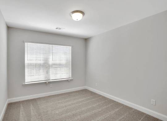 Harris Trail Luxury Townhomes for rent Richmond Hill, GA photo of bedroom with large window and plush carpeting