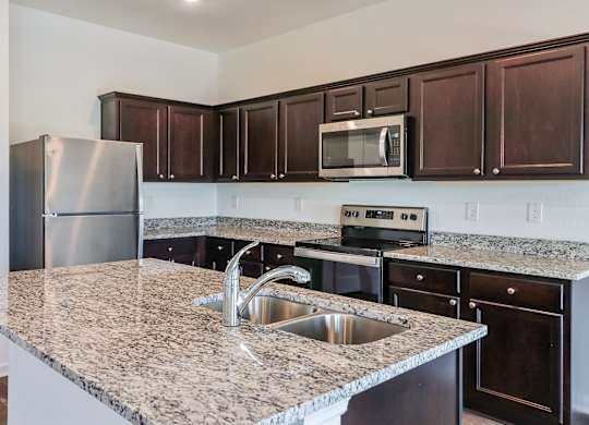 A kitchen with granite countertops and stainless steel appliances.