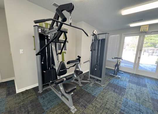 A gym with a weight machine and a squat rack.