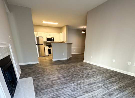 A living room with a grey floor and a television on the left side.