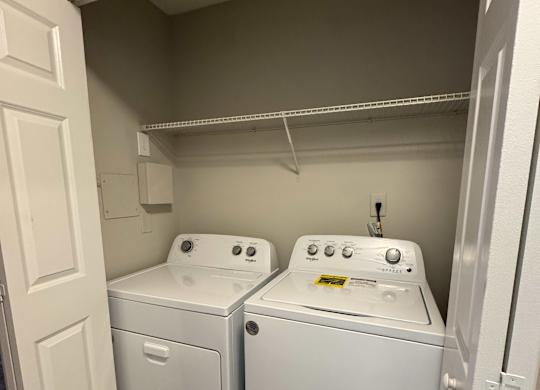 A small laundry room with a washer and dryer.