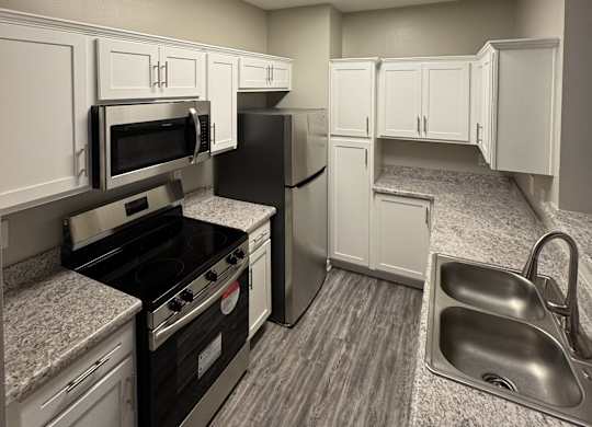 A kitchen with black appliances and white cabinets.
