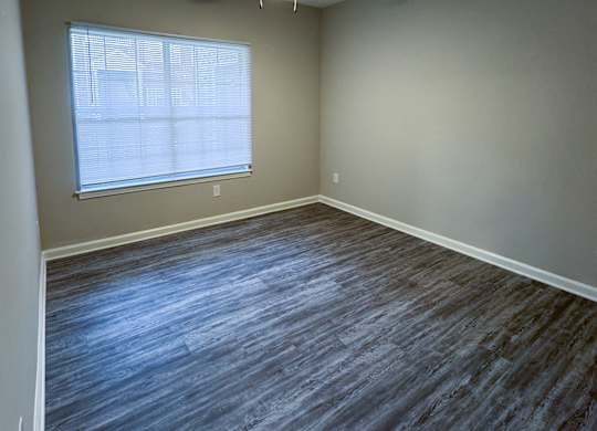 A room with a ceiling fan and a window with blinds.