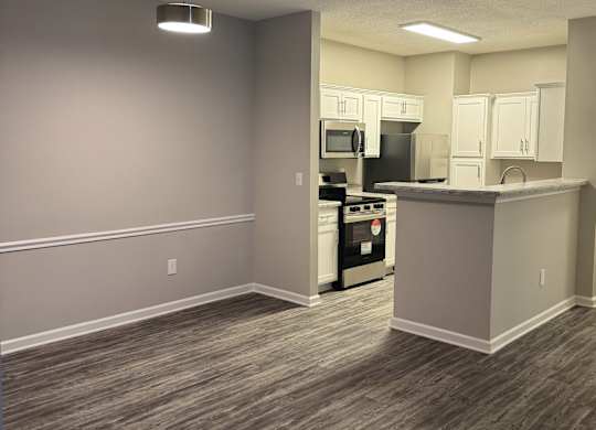 A kitchen area with a stove, oven, microwave, and refrigerator.