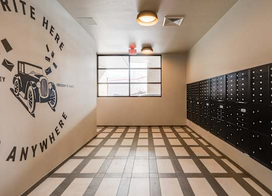 A room with a black and white checkered floor and a white wall with a vintage car and the words