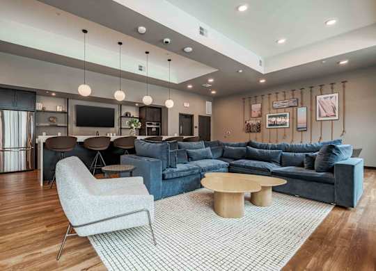 A modern living room with a grey sofa, a white chair, and a wooden coffee table.