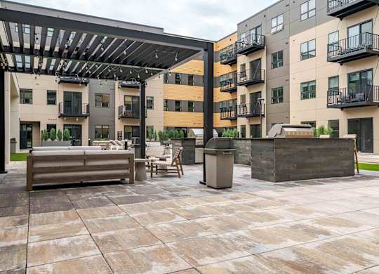 A patio area with a table and chairs under a roof.