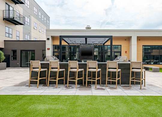 A patio with chairs and a table in front of a building.