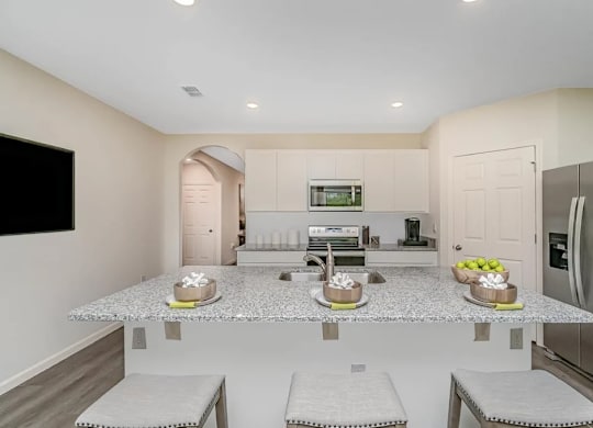 A kitchen with a granite countertop and stainless steel appliances.