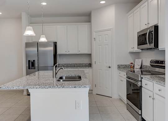 A kitchen with white cabinets and appliances.