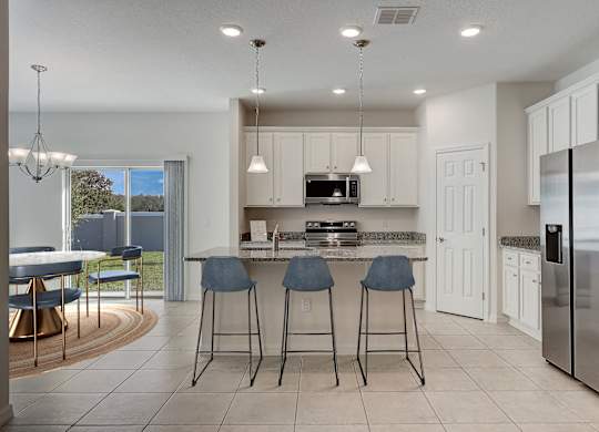 A modern kitchen with a bar area and a refrigerator on the right.