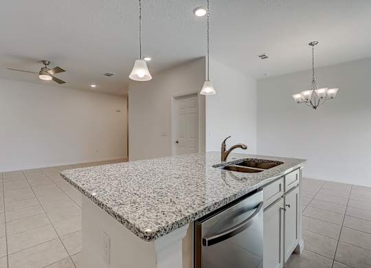 A kitchen with a granite countertop and a dishwasher.