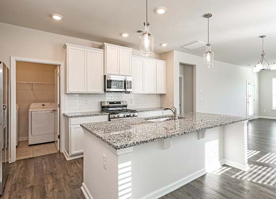 A kitchen with a granite countertop and white cabinets.