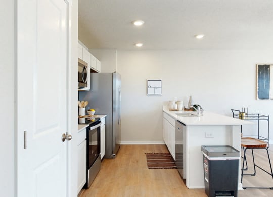 an open kitchen and dining room with a stainless steel refrigerator and stove and a counter