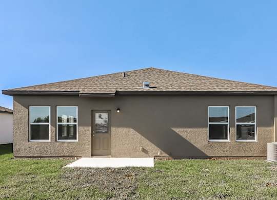 A house with a brown roof and tan walls with a brown door and windows.