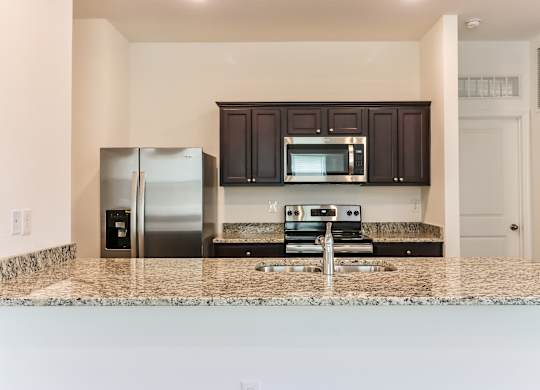 A kitchen with granite countertops and stainless steel appliances.