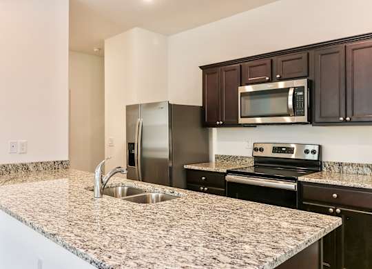 A kitchen with granite countertops and stainless steel appliances.