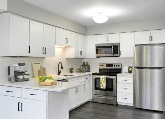 Laurel West End Apartments in Golden Valley, MN photo of kitchen with white cabinets, stainless-steel appliances and hardwood flooring