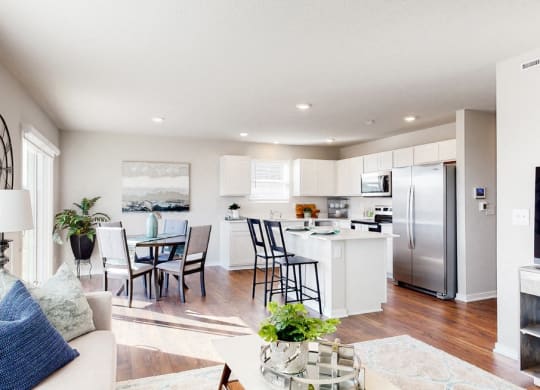 a living room with a kitchen and a table with chairs