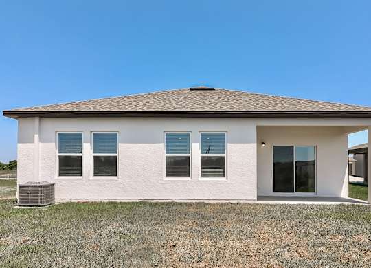 A white house with a brown roof and a glass door.