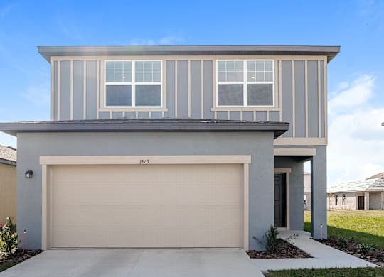 A modern house with a garage door and a driveway.