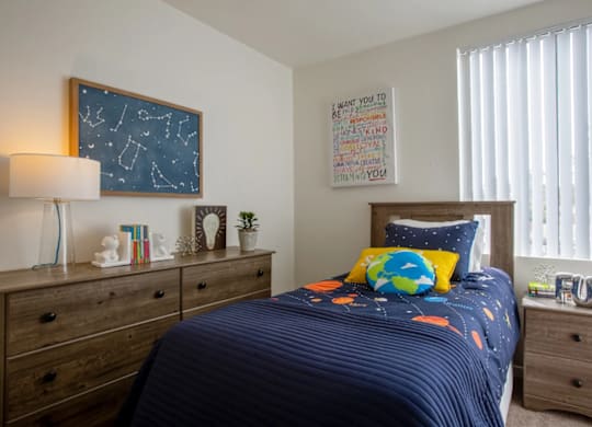 Bright bedroom with large window at Midtown on Seneca, a pet-friendly apartment community near East Central Tucson, Tucson, AZ.