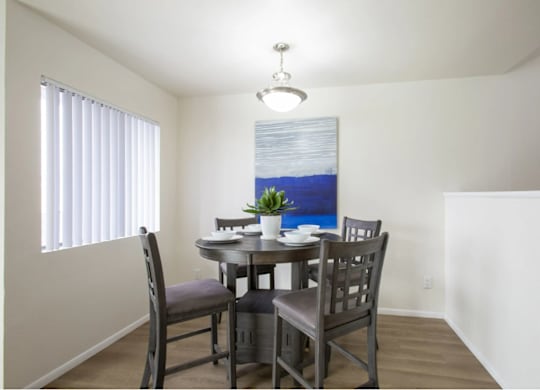 Dining room with window and wood-style flooring at Midtown on Seneca, a pet-friendly apartment community near East Central Tucson, Tucson, AZ.