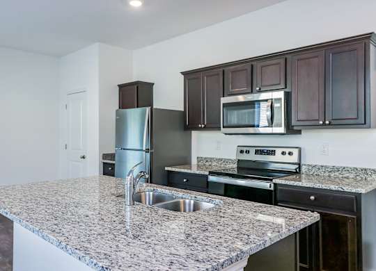 A kitchen with granite countertops and stainless steel appliances.