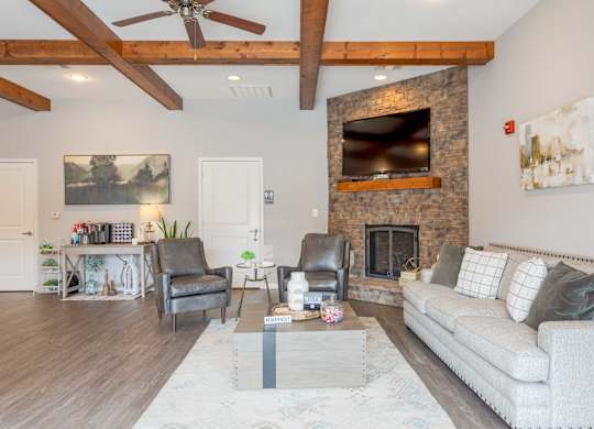 One, Two and Three- Bedroom Apartments for Rent in Sevierville, TN – Overlook at Allensville – clubhouse seating area with a fireplace and a couch.