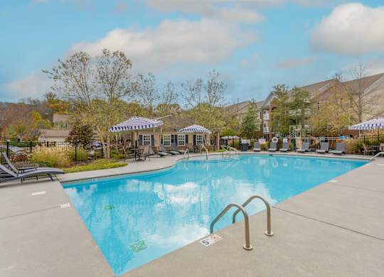 One, Two and Three- Bedroom Apartments for Rent in Sevierville, TN – Overlook at Allensville – A large swimming pool with seating areas and umbrellas