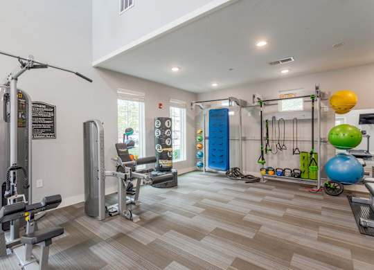 One, Two and Three- Bedroom Apartments for Rent in Sevierville, TN – Overlook at Allensville – A gym with a variety of equipment including a treadmill, weights, and exercise balls.