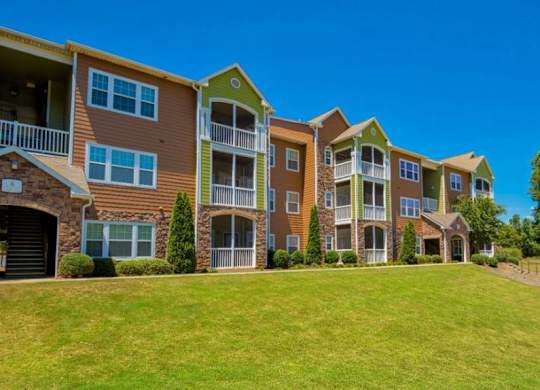 Pet-Friendly Apartments in Opelika, AL – The Crossings of Opelika - community building and grass area