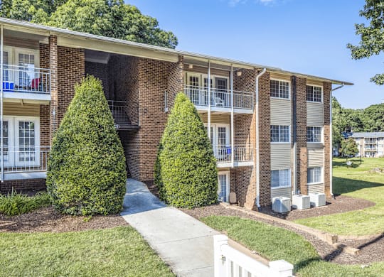 Apartment complex exterior with balconies and landscaping at Grand Arbor Reserve Apartments in Raleigh, NC 27607, near Central Raleigh.